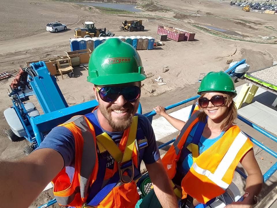 Joe and Flo on the job in hard hats and safety vests at a Nebraska work site